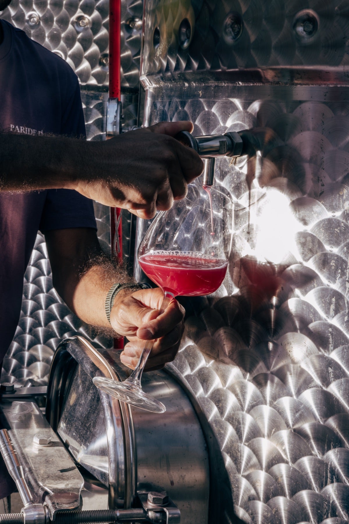 A fresh wine sample being drawn from a stainless steel tank